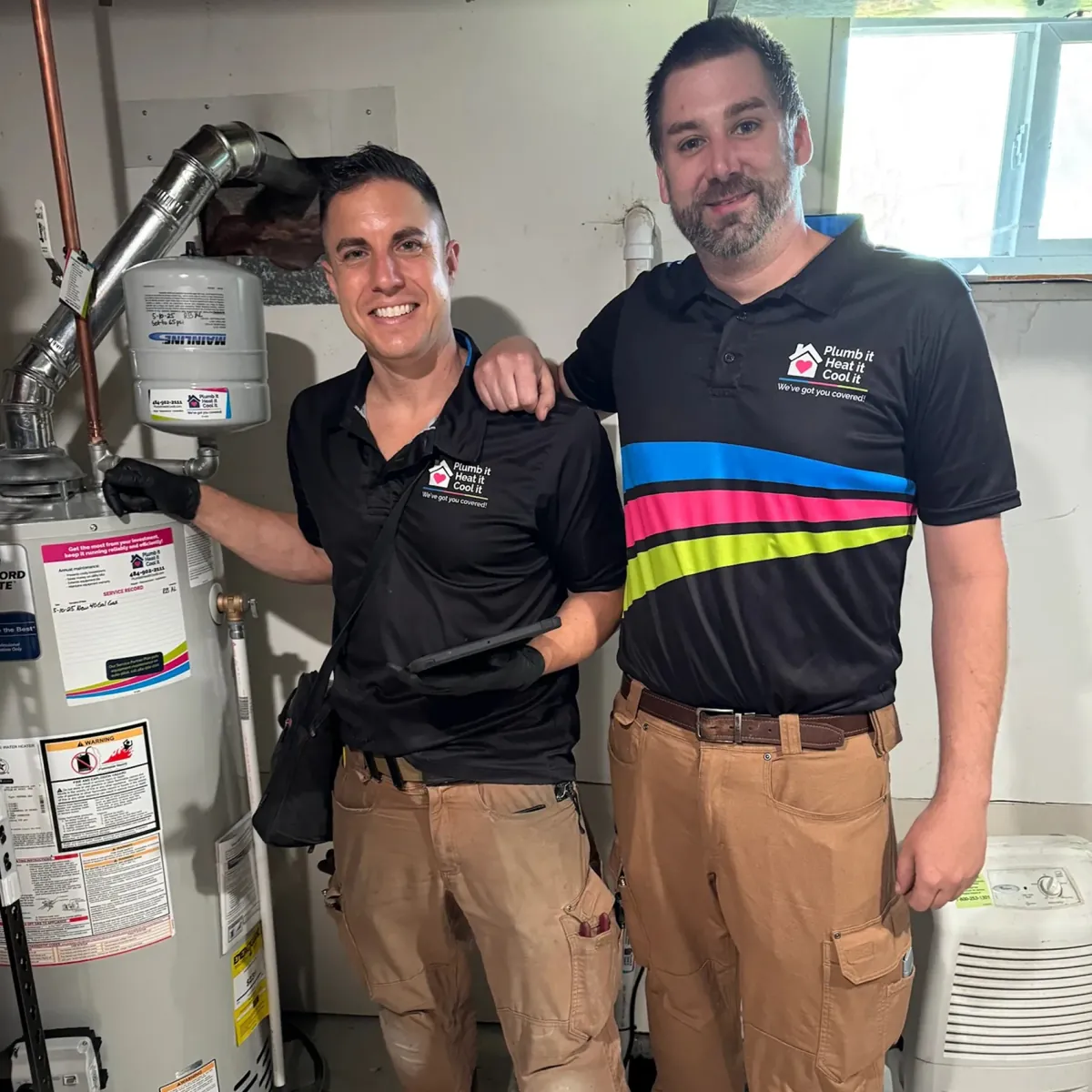 Two licensed Plumb it Heat it Cool it plumbers installing a home water heater