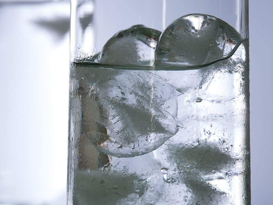 A glass of water with ice cubes.